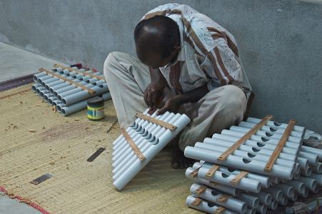 Un indien de la fabrication d'instruments de musique travaille sur un instrument