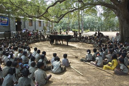 Salem Ecole tribale dans les collines - Les enfants sont installés autour du piano sous un immense arbre. Ella et Marc (notre ingénieur son) ouvre le concert par un 4 mains